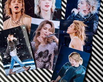 Könnte beinhalten: Eine Sammlung von sechs Fotoabzügen, die eine Person mit blonden Haaren in verschiedenen Posen zeigen. Die Bilder zeigen die Person beim Singen in ein Mikrofon und beim Posen. Der Hintergrund ist ein schwarz-weiß gestreiftes Muster.
