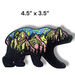 May include: Black bear patch with a mountain and starry night design. The patch measures 4.5 inches by 3.5 inches. The bear silhouette is black, with a colorful mountain scene in the center.