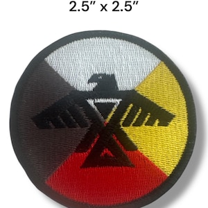 May include: A 2.5 inch by 2.5 inch embroidered patch featuring a black eagle with outstretched wings. The eagle is centered on a circle with four colored sections: black, white, red, and yellow.