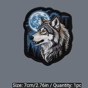Peut inclure: Un écusson brodé représentant une tête de loup de profil devant une pleine lune et une forêt sombre. Le loup a un pelage gris, blanc et marron avec des yeux ambrés. L'écusson a une bordure noire et mesure 7 cm de dimension.