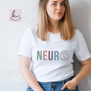 Pode incluir: Uma camiseta branca com a palavra "NEURO" impressa em letras coloridas, com um gr&aacute;fico de c&eacute;rebro estilizado ao lado.