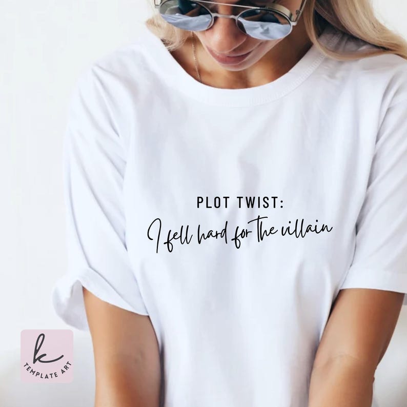 K&ouml;nnte beinhalten: Wei&szlig;es T-Shirt mit dem Text "PLOT TWIST: I fell hard for the villain" in schwarzer Schrift. Das Shirt ist schlicht und hat kurze &Auml;rmel. Das Bild zeigt eine Person, die das Shirt tr&auml;gt.