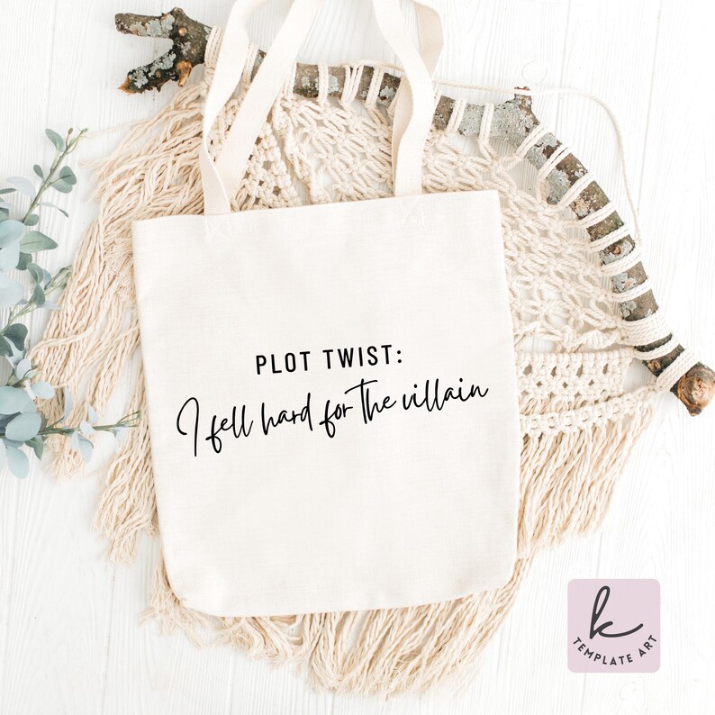 K&ouml;nnte beinhalten: Cremefarbene Tragetasche mit dem Text "PLOT TWIST: I fell hard for the villain" in schwarzer Schrift. Die Tasche hat lange Tr&auml;ger und wird vor einem neutralen, strukturierten Hintergrund pr&auml;sentiert.