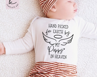 May include: White baby onesie with black text that reads "Hand picked for earth by my Poppy in heaven" with angel wings and a halo above the text.