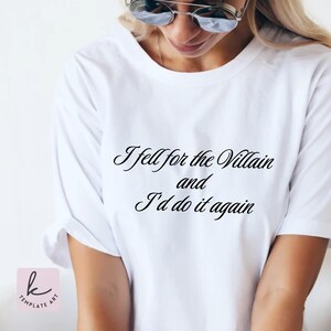 Könnte beinhalten: Weißes T-Shirt mit dem Text "I fell for the Villain and I'd do it again" in schwarzer Schrift. Das Oberteil hat kurze Ärmel und einen Rundhalsausschnitt. Das T-Shirt ist aus weichem Material.