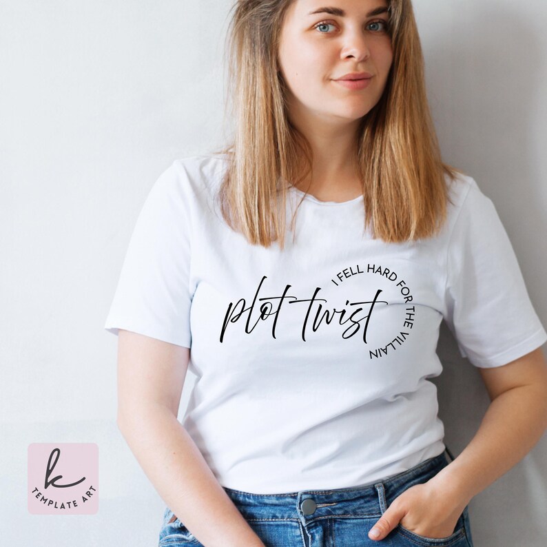 Op de afbeelding: Wit T-shirt met de woorden "plot twist" in een stijlvol lettertype. De zin "I fell hard for the villain" is in een cirkelvormig lettertype rond de hoofdtekst geschreven. Het shirt wordt door een persoon gedragen.