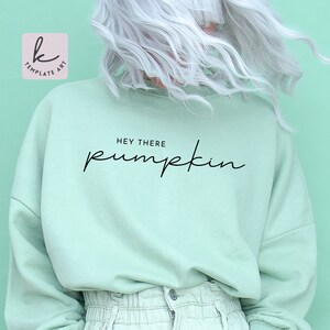 May include: A light green sweatshirt with the text "Hey there pumpkin" in black script font.