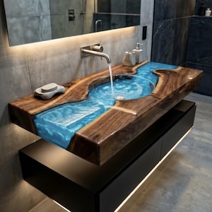 May include: A floating bathroom vanity featuring a live-edge wood countertop with a central basin filled with translucent blue resin. A silver faucet dispenses water into the basin. The vanity includes a matte black cabinet with under-cabinet lighting.