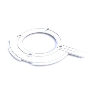 Puede incluir: Pieza de plástico blanca con forma circular y un pequeño brazo que se extiende hacia un lado. La pieza tiene cinco pequeños agujeros alrededor del borde del círculo.