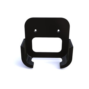 Può includere: Supporto da parete in plastica nera con due fori per viti di fissaggio. Il supporto ha un design curvo per tenere un dispositivo.