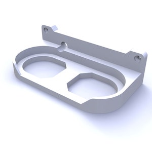 Puede incluir: Un soporte de pared de plástico blanco con dos recortes circulares. El soporte tiene un pequeño agujero en la parte superior para colgarlo.