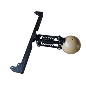 Puede incluir: Un soporte de cámara de metal negro con una cámara esférica beige unida. El soporte tiene un acabado texturizado y está diseñado para ser fijado a una superficie.