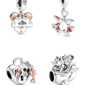 May include: Four silver charm bracelets featuring Mickey Mouse and Minnie Mouse. The charms include Mickey Mouse and Minnie Mouse with their hands over their eyes, Mickey Mouse and Minnie Mouse holding hands, Mickey Mouse and Minnie Mouse in a heart-shaped lock with a key, and Mickey Mouse and Minnie Mouse flying in an aeroplane.