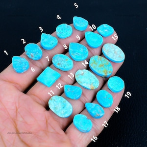 Könnte beinhalten: Eine Sammlung von neunzehn Türkis-Edelsteinen in verschiedenen Formen und Größen, darunter ovale, tropfenförmige und unregelmäßige Formen. Die Edelsteine haben eine leuchtende blaugrüne Farbe, wobei einige braune Matrixmuster aufweisen. Das Bild ist nummeriert.