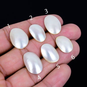 May include: Six oval-shaped white mother of pearl cabochons, numbered 1 through 6.