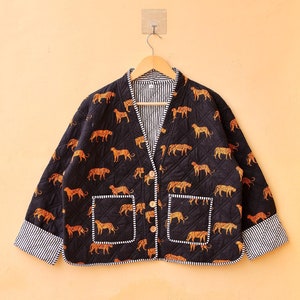 Pode incluir: Uma jaqueta acolchoada preta com fecho de botão e dois bolsos. A jaqueta é estampada com estampa de animais laranja e marrom.