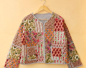 May include: A brown quilted jacket with a patchwork design featuring floral and geometric patterns. The jacket has a button closure and two pockets.