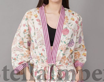 May include: A white floral print robe with pink and white stripes down the sides. The robe has a tie belt and two pockets.