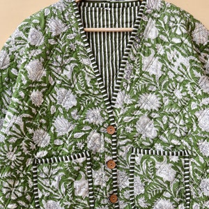 Puede incluir: Una chaqueta acolchada verde con estampado floral blanco y forro a rayas. La chaqueta tiene cierre de bot&oacute;n y dos bolsillos.