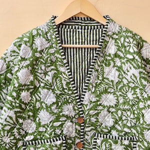 Puede incluir: Una chaqueta acolchada verde con estampado floral blanco y forro a rayas. La chaqueta tiene cuello en V, cierre de bot&oacute;n y dos bolsillos de parche.