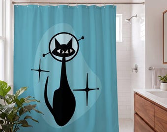 May include: A light blue shower curtain featuring a large black silhouette of a cat wearing a space helmet. The design includes a pale blue organic shape behind the cat and two black four-pointed starburst symbols on either side.