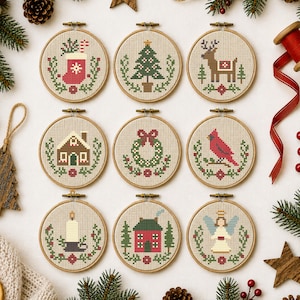 May include: Nine circular wooden embroidery hoops containing cross-stitch patterns featuring Christmas themes including a stocking, a tree, a reindeer, a house, a wreath, a cardinal, a candle, a cottage, and an angel on light fabric.