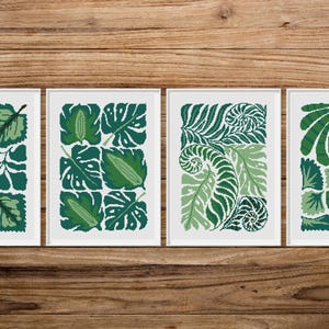 May include: Four framed prints featuring different green leaf patterns. Each print showcases a unique design of stylised leaves and branches.