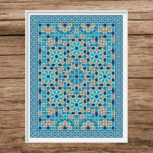May include: A framed geometric pattern print featuring a symmetrical design in shades of blue, teal, and tan. The artwork has a white border and a detailed repeating pattern, creating a visually appealing piece.