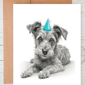 Puede incluir: Un dibujo en blanco y negro de un perro pequeño con un gorro de fiesta azul. El perro está acostado y mirando a la cámara.