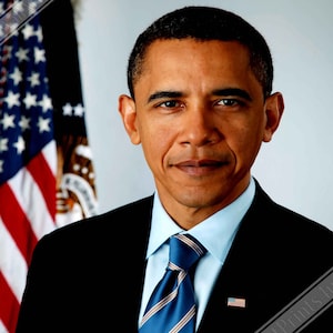 Puede incluir: Un retrato de Barack Obama con un traje azul oscuro, camisa azul claro y corbata a rayas azul y marrón. Está de pie frente a una bandera estadounidense.