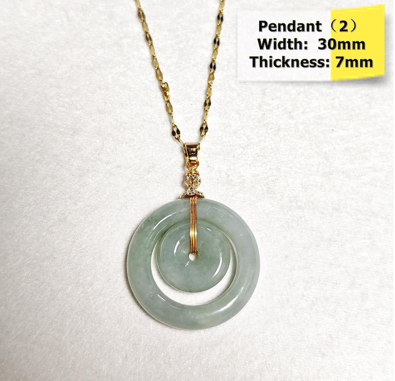 May include: A gold-colored chain necklace with a jade pendant. The pendant features two concentric circles of pale green jade, with a width of 30mm and a thickness of 7mm. The text "Pendant (2)" is visible.