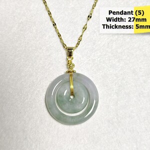 May include: A gold-toned necklace with a jade pendant. The pendant is a double-hoop design in shades of green and white, with a width of 27mm and a thickness of 5mm. The necklace chain is delicate and complements the pendant's design.