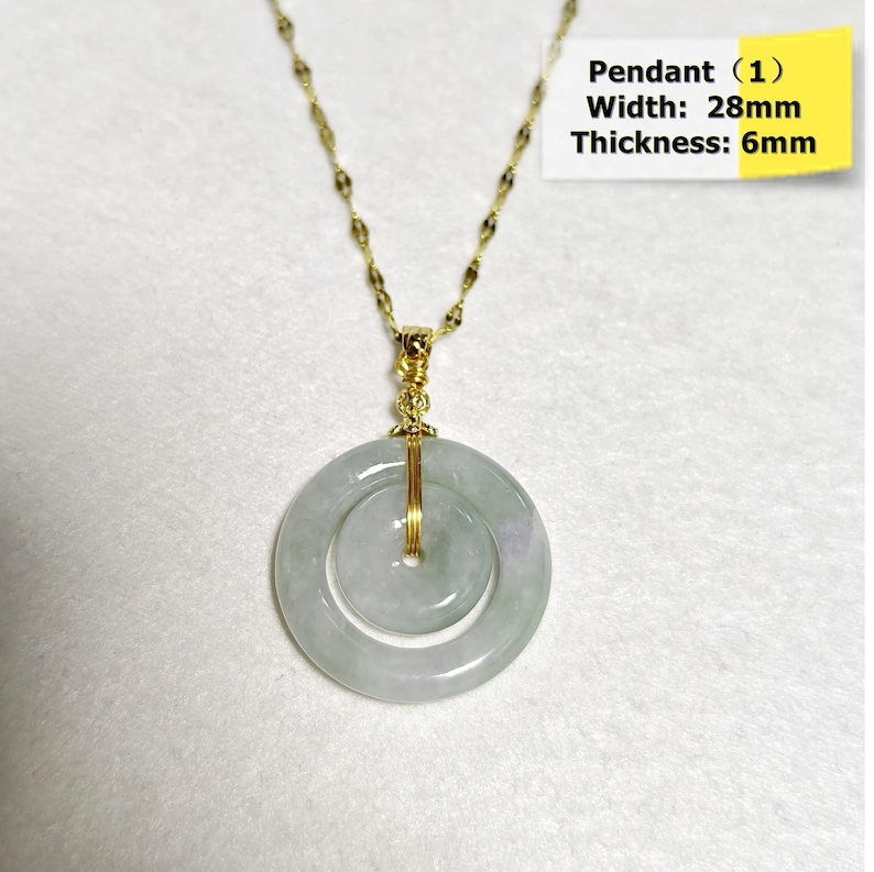 May include: A gold-colored chain necklace with a jade pendant. The pendant is a double-hoop design, with a width of 28mm and a thickness of 6mm. The jade has a pale green and white color. The text on the image says "Pendant (1) Width: 28mm Thickness: 6mm".