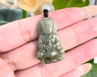 May include: A green jade pendant carved in the shape of a seated Buddha. The pendant is detailed with a serene facial expression and intricate carvings on the clothing.
