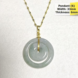 May include: A gold-colored chain necklace with a jade pendant. The pendant is a double-circle design, with a width of 33mm and a thickness of 6mm. The pendant is light green and has a gold-colored wire wrapped around it. The text "Pendant (6) Width: 33mm Thickness: 6mm" is in the image.