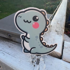 Bonita pegatina de dinosaurio kawaii: adorable dinosaurio verde con mejillas rosadas, perfecta para cuadernos, portátiles, botellas de agua y diarios infantiles