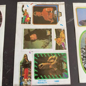 May include: Sheet of vintage wrestling stickers featuring various wrestlers in action poses. The stickers have colorful backgrounds and borders. Some stickers include the WWF logo. The sheet also includes the text "MADE IN INDIA" and "NOVELTY".
