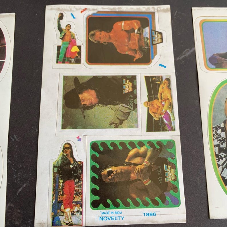 May include: Sheet of vintage wrestling stickers featuring various wrestlers in action poses. The stickers have colorful backgrounds and borders. Some stickers include the WWF logo. The sheet also includes the text "MADE IN INDIA" and "NOVELTY".