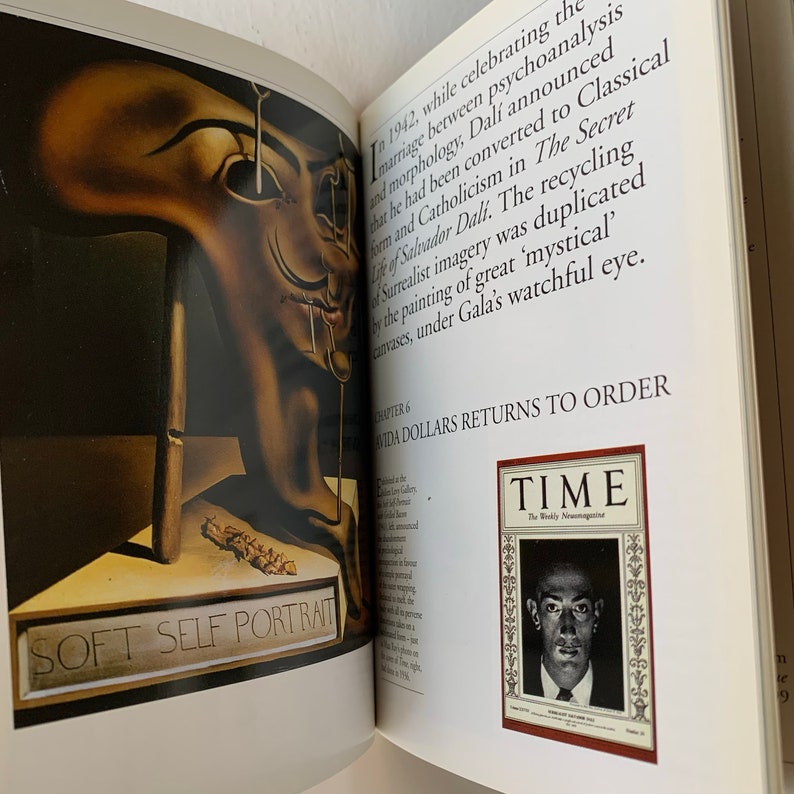 May include: An open book with a painting of a distorted human face on the left page. The right page features a magazine cover with the word "TIME" in red and white lettering. The magazine cover features a black and white photo of a man with a serious expression.