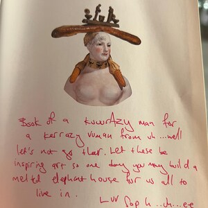 May include: A book titled "The Impresario of Surrealism" by Jean-Louis Gaillemin with a handwritten note on the cover that reads "Book of a kuwrAzy man for a kerrazy vuman from un....wel let's not go ther. Let these be inspiring art so one day you may build a meled elephant house for us all to live in. Luv Soph..ch...ee xxx"