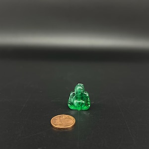 May include: A small green glass figurine of a meditating Buddha.