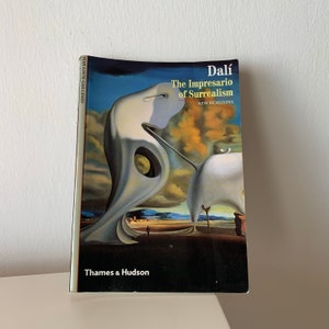 May include: A book cover featuring a painting of a surreal landscape. The title is "Dal&iacute; The Impresario of Surrealism" with the subtitle "New Horizons". The author is Jean-Louis Gaillemin. The book is published by Thames & Hudson.