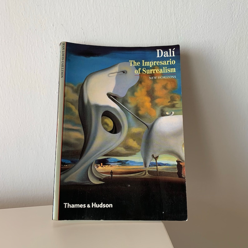May include: A book cover featuring a painting of a surreal landscape. The title is "Dal&iacute; The Impresario of Surrealism" with the subtitle "New Horizons". The author is Jean-Louis Gaillemin. The book is published by Thames & Hudson.