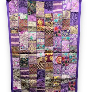 Peut inclure: Une courtepointe patchwork violette avec une variété de motifs et de textures colorés. La courtepointe est faite de nombreux tissus différents, dont le velours, le brocart et la broderie. La courtepointe est bordée d'une bordure violette.