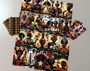 May include: A full deck of tarot cards with colorful illustrations featuring people of color. The cards are laid out in a spread, showing the major arcana cards, including The Fool, The Magician, The High Priestess, The Empress, The Emperor, The Hierophant, The Lovers, The Chariot, Strength, The Hermit, Wheel of Fortune, Justice, The Hanged Man, Death, Temperance, The Devil, The Tower, The Star, The Moon, The Sun, and The World.