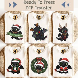 May include: Six off-white t-shirts with different Christmas-themed dragon designs. Each shirt features a cartoon dragon wearing a Santa hat, reindeer antlers, or a Christmas wreath. The text "Ready To Press DTF Transfer" is at the top.