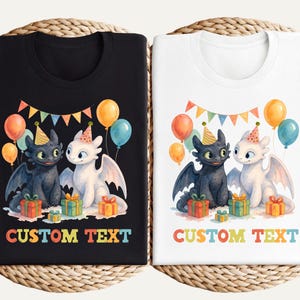 May include: Black and white t-shirts featuring a cartoon dragon couple with party hats, balloons, and gifts. The shirts have the text "CUSTOM TEXT" in colorful letters. The design is set against a woven background.