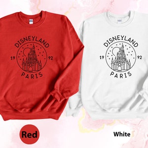 Puede incluir: Dos sudaderas, una roja y otra blanca, con un gr&aacute;fico negro del castillo de Disneyland Par&iacute;s y el texto "DISNEYLAND PARIS 1992".