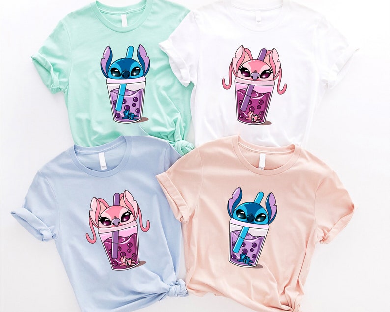 May include: Four t-shirts in pastel colors: mint green, white, light blue, and peach. Each shirt features a cartoon character in a boba drink cup with purple boba pearls and a straw. The characters are blue and pink.