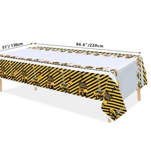 Op de afbeelding: Een wit plastic tafelkleed met een geel en zwart bouwthema. Het tafelkleed heeft een herhalend patroon van bouwvoertuigen en de woorden "Happy Birthday". Het tafelkleed meet 220 cm bij 130 cm.